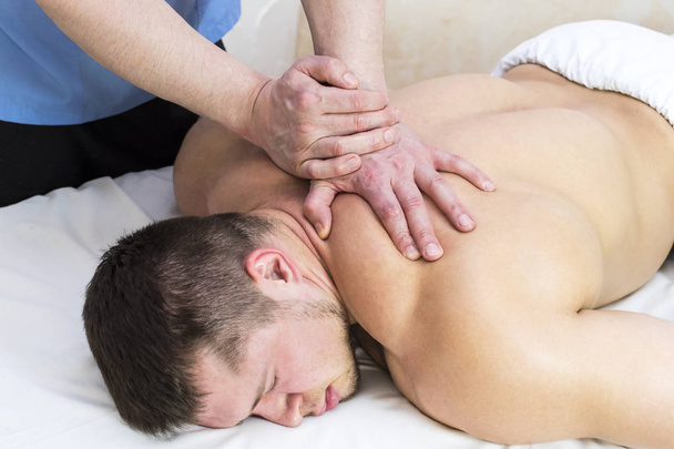 uomo che fa massaggio sportivo - Foto, immagini
