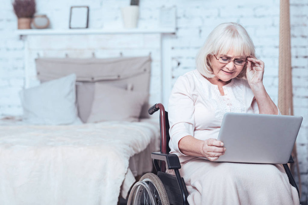 Aged disabled woman using gadget at home - Fotó, kép
