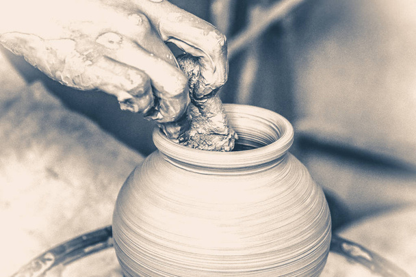 Velho estilo vinícola. Mãos de homem e ferramenta fazendo jarro de argila macro
. - Foto, Imagem
