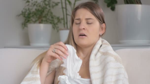 Крупный план молодой женщины, страдающей аллергией чихающей на бумажный носовой платок
 - Кадры, видео