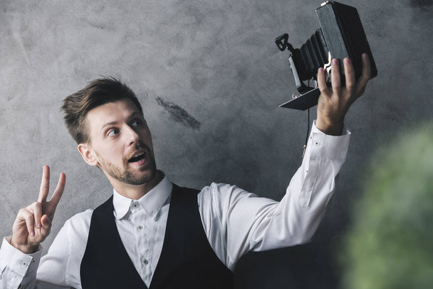 Hombre tomando selfie con cámara retro
 - Foto, Imagen