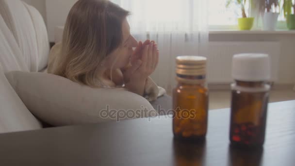 Νεαρή γυναίκα υλοτόμηση άρρωστος caughing στο κρεβάτι και παίρνετε τα χάπια από το κομοδίνο - Πλάνα, βίντεο