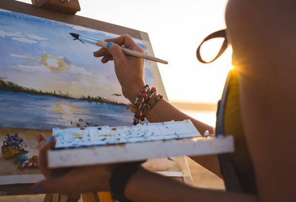junge Künstlerin bemalt Landschaft unter freiem Himmel am Strand, Nahaufnahme - Foto, Bild