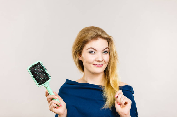 Woman brushing her long hair with brush - Фото, зображення