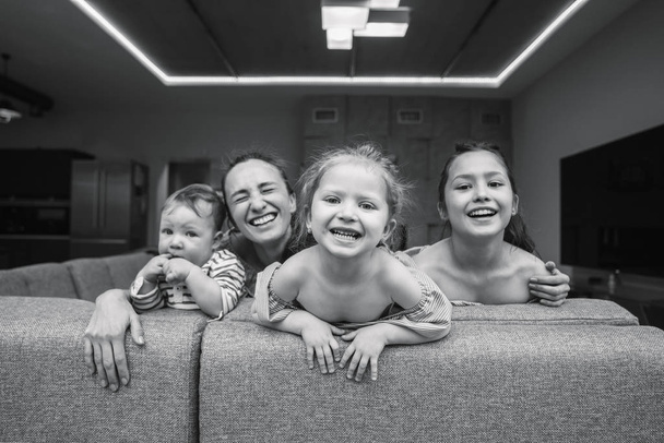 Mom, two daughters and a little son on the couch - Photo, image