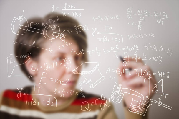 Розмитий професор пише формули на прозорій дошці
 - Фото, зображення