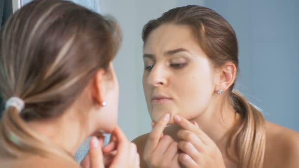 4 k close-up beelden van jonge vrouw controleren van de huid op de spiegel in de badkamer - Video