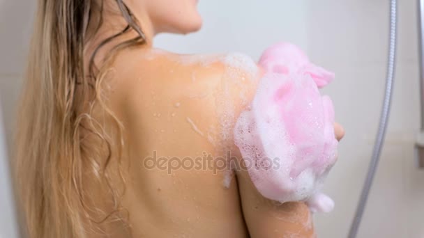 Gros plan ralenti de sexy jeune femme frottant corps avec éponge rose à la douche
 - Séquence, vidéo