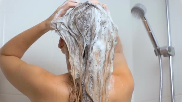 Imágenes en cámara lenta de una mujer con cabello largo aplicando champú en el baño
 - Imágenes, Vídeo