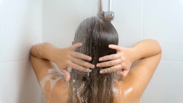 Nahaufnahme-Video einer sexy brünetten Frau mit langen Haaren beim Waschen unter der Dusche - Filmmaterial, Video