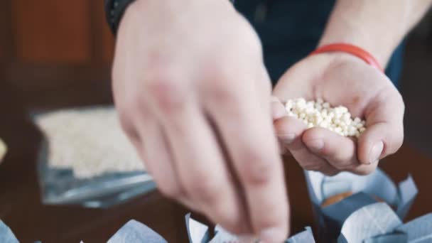 Las manos masculinas confitero decoran magdalena con bolitas de arroz
 - Metraje, vídeo