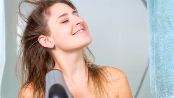Retrato de câmera lenta de bela mulher secando o cabelo com secador de cabelo
 - Filmagem, Vídeo