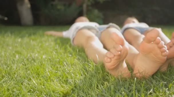 Dolly atış iki kız ayak Park'ta çim üzerinde yalan - Video, Çekim