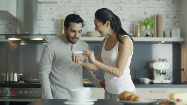 On the Kitchen Beautiful Girl Shows Pregnancy Test Result to Her Boyfriend and they Embrace. Both are very Happy. - Materiał filmowy, wideo