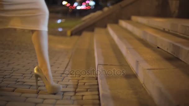 Sexy jonge vrouw op hoge hakken lopen de trap op straat 's nachts - Video