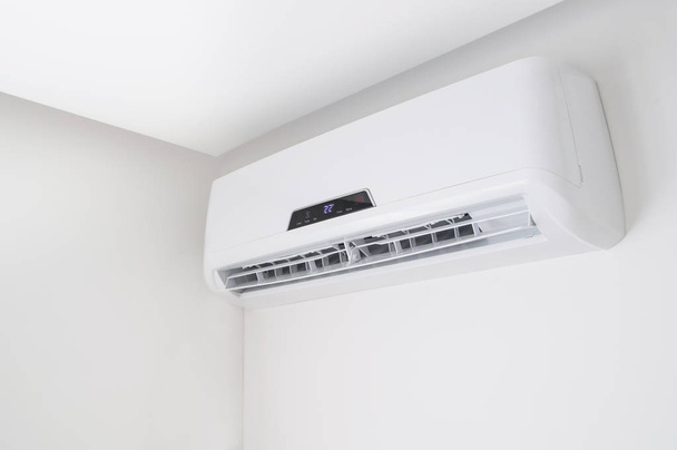 Split air conditioner on a white wall in flat indoors - 写真・画像