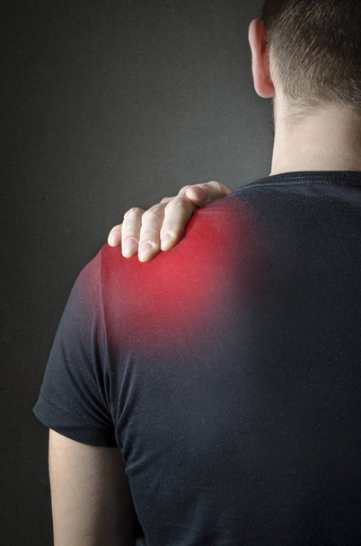 Back view of a Man with neck pain over dark background.  - Photo, Image