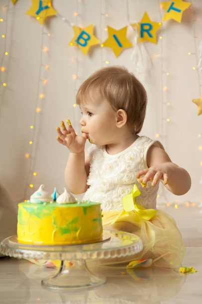 kleines Baby Geburtstag ein Jahr Mädchen zerquetscht ihre gelbe Torte - Foto, Bild