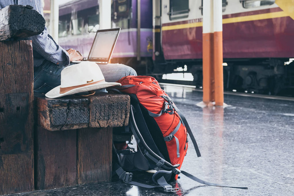 ビジネスの男性は、ラップトップを使用して座っています。電車で旅行バッグ  - 写真・画像