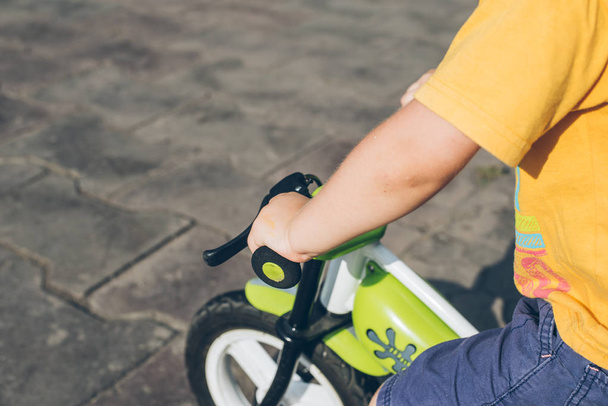 Child hand on the bicycle steering wheel - Φωτογραφία, εικόνα