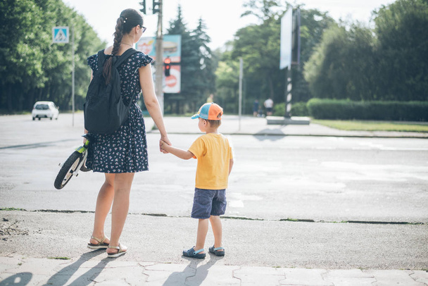 mother with son stands on traffic light - Φωτογραφία, εικόνα