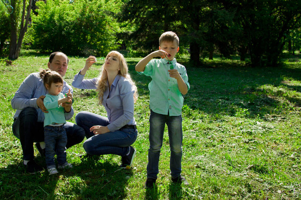 A family of four people are allowed to make soap bubbles.  - 写真・画像