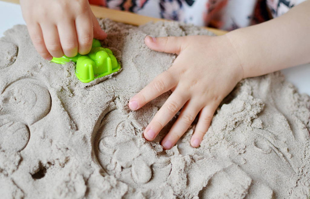 Девушка играет с кинетическим песком
 - Фото, изображение