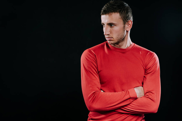 Portrait of handsome Caucasian sportsman wearing red sportswear and posing after exercises on dark background. Healthy inspirational fitness lifestyle, sport motivation. - Photo, Image