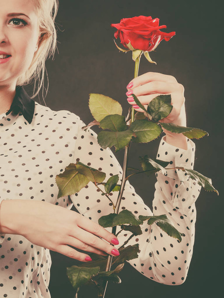 Woman holding rose flower on black - Фото, изображение