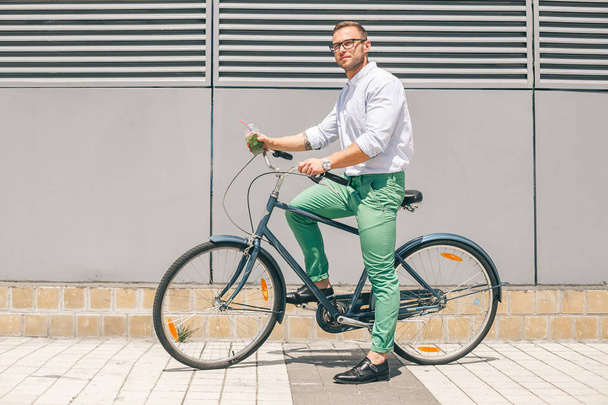 Pensive casual businessman going to work by bicycle - Foto, Imagen