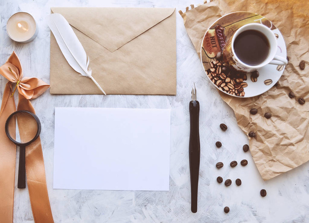 Vintage mockup. Blank paper and envelope, candle, feather, coffee cup, pen, crumpled paper, coffee beans - Photo, image