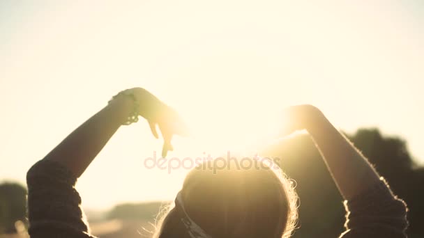 梨花は、太陽の光で手します。太陽に手を振っています。女の子は、太陽にアウトに達する。スローモーション - 映像、動画