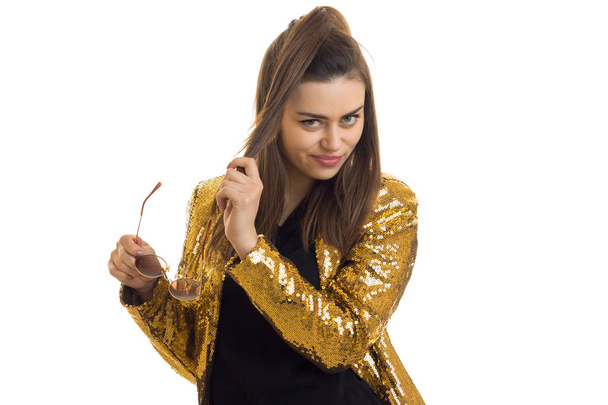 Pretty stylish brunette in golden jacket posing on camera - Foto, Bild