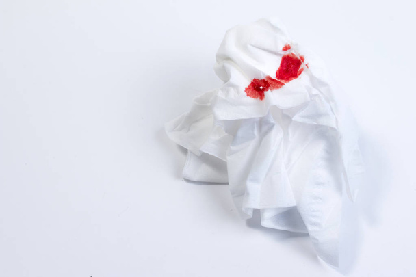 Wundblut, Blut auf Seidenpapier auf weißem Hintergrund. Nasenbluten oder Epistaxis Behandlung Blut in Seidenpapier. Gesundheitsmedizin. - Foto, Bild