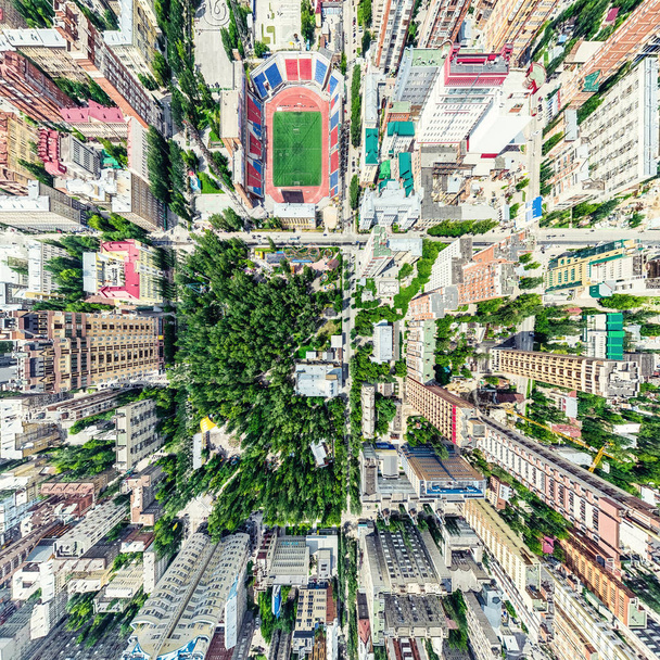 Aerial city view with crossroads and roads, houses, buildings, parks and parking lots. Sunny summer panoramic image - Zdjęcie, obraz