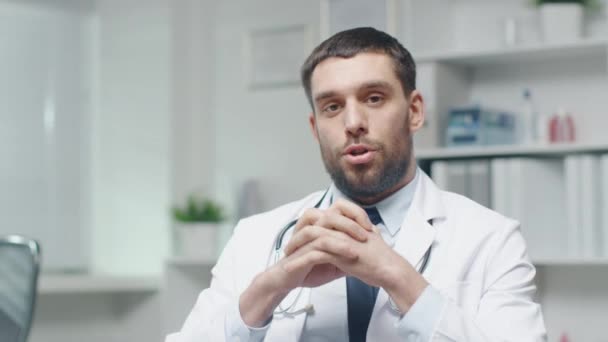 Male Doctor Speaks into the Camera While Sitting in His Office. - Záběry, video