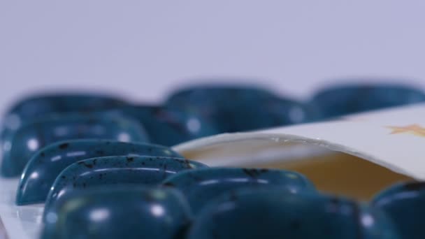 Dulces azules alrededor del logo del equipo de cerca. Caramelos en la mesa. Piruletas azules y negras. Movimiento lento
 - Metraje, vídeo
