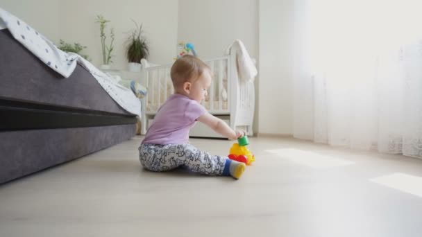 Dolly shot of cute toddler boy playing on floor at living room - Felvétel, videó