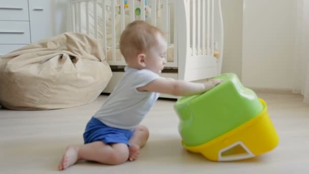 Cute toddler boy crawling on floor and playing with potty - Footage, Video