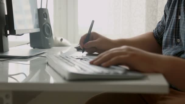 Closeup πυροβόλησε νεαρός σχεδιαστής εργασίας με σχέδιο tablet στο γραφείο - Πλάνα, βίντεο