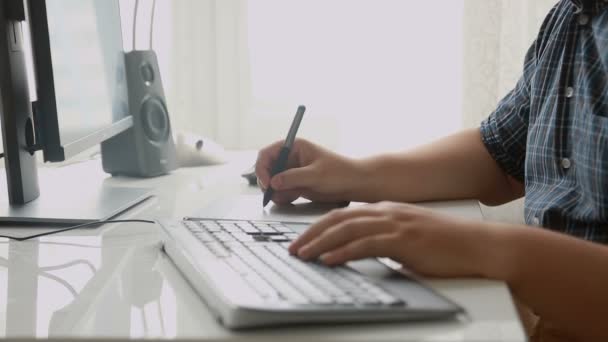 Close-up de jovem designer profissional trabalhando com tablet desenho digital e teclado no escritório
 - Filmagem, Vídeo