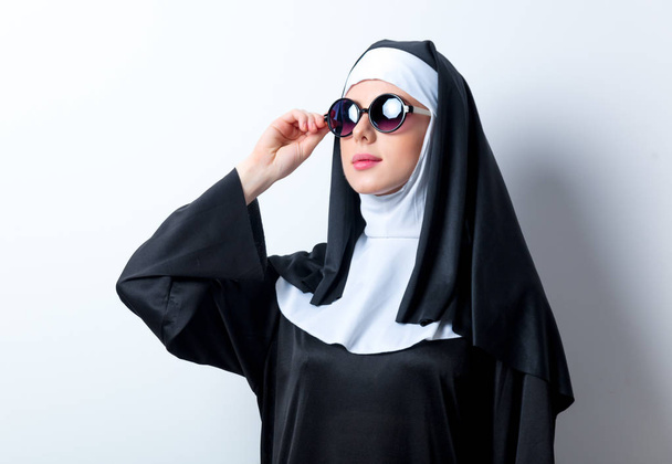 серьезная монахиня в солнечных очках
 - Фото, изображение