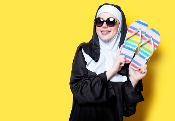 Rahibe ile güneş gözlüğü ve flip flop  - Fotoğraf, Görsel