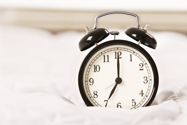 Alarm clock on white bed - Photo, Image