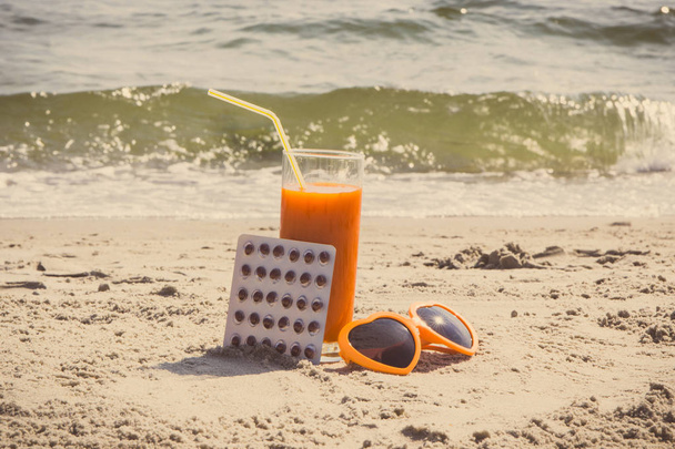 Photo vintage, pilules médicales, jus de carotte et lunettes de soleil à la plage, vitamine A et beau bronzage durable
 - Photo, image