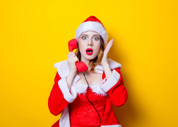 Cep telefonu ile kırmızı giysili Noel Baba kızı  - Fotoğraf, Görsel