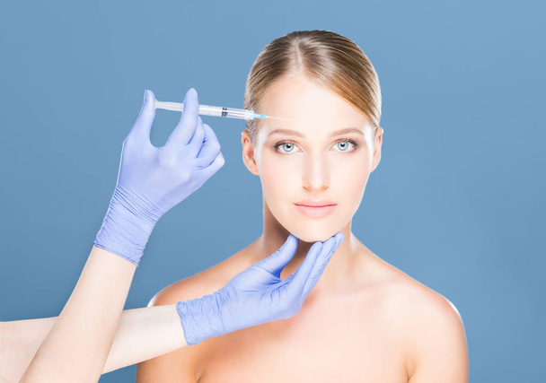 Doctor making injection into face of woman - Photo, image