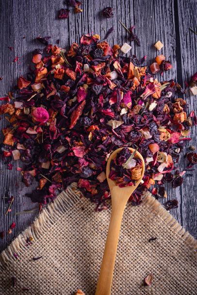 Mix tea with dried fruits and dried flowers and wooden spoon - Foto, Bild