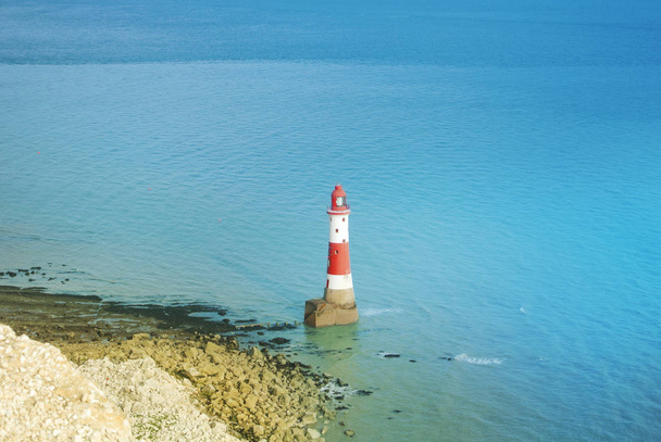 Aerial view to Beachy Head Lighthouse with blue turquoise water of English channel at the background and white chalk stones of cliffs, Seven Sisters country park, Eastblurne, East Sussex, England, UK. - Foto, immagini