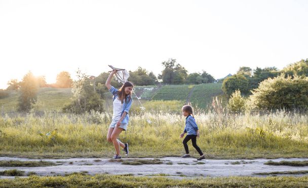 Молода мати з дочкою грає з повітряним змієм
 - Фото, зображення